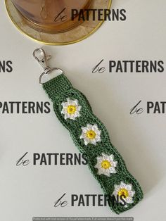 a crocheted key chain with daisies on it