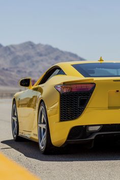 a yellow sports car driving down the road