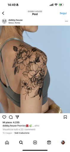 the back of a woman's shoulder with flowers on it and an arrow in the middle