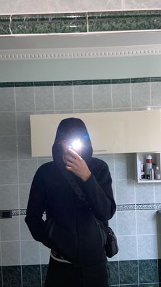 a person standing in front of a mirror holding a cell phone