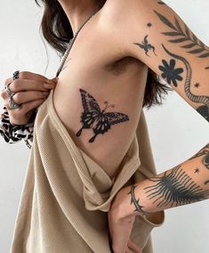 a woman with tattoos on her chest and arm