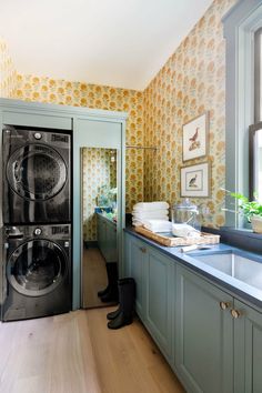 a washer and dryer in a room with yellow wallpaper on the walls