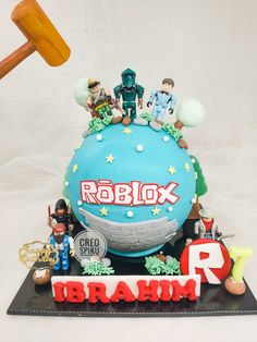 a birthday cake with the name roblox on it and various figurines