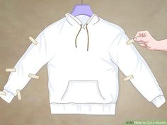 a white hoodie being cut out with clothes pins on the front and back of it