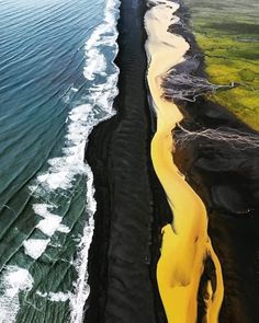 an aerial view of black sand beach and the ocean with waves coming in to shore