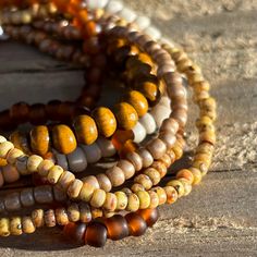 This is a lovely coordinated stack of 6 stretch seed bead and wood bracelets in earthy brown tones. Perfect for dressing up, a casual day out, or no occasion at all! Rearrange the bracelets to get the exact style you like, or add them to some of your existing favorites to customize your accessorizing. Looks fantastic paired with gold. Set includes one each of: deep amber, Picasso matte canary yellow, Picasso matte brown, off-white/stone solid color, metallic khaki, and one wood bead bracelet.  As a handmade item, each set will vary slightly due to randomization of patterns.  Giving as a gift? The 7" size is considered "standard" and fits a lot of teens and adults. Treating yourself? Measure your wrist to choose your desired size. Selecting a set that's a little larger means the stack will Bohemian Brown Stretch Bracelet For Beach, Bohemian Brown Stretch Bracelet With Colorful Beads, Bohemian Brown Bracelet With 108 Beads, Bohemian Brown Bracelet With Tiny Beads, Spiritual Brown Beaded Bracelets With Wooden Beads, Spiritual Brown Wooden Beaded Bracelets, Brown Heishi Beads Bracelet, Spiritual Brown Beaded Bracelets For Everyday, Rustic Brown Bracelets For Everyday