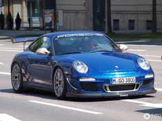 a blue sports car driving down the street