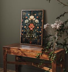 there is a painting on the table next to some flowers