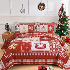 a christmas themed bed spread with reindeers and snowflakes on it, next to a tree