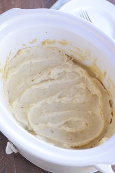 a white bowl filled with batter on top of a wooden table