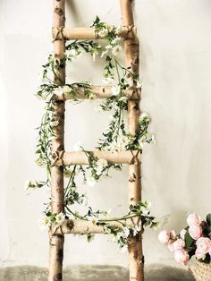 a ladder made out of branches with flowers on it