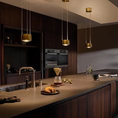 a kitchen that has some lights hanging from the ceiling above it and is very nice