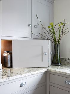 a vase with some flowers in it sitting on a counter next to a microwave oven