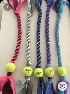 several tennis balls tied to different types of ties on a white surface with the word e g written on them