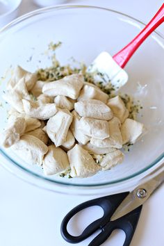 a bowl filled with cut up food next to a pair of scissor blades