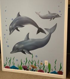 two dolphins swimming in the ocean with corals and seaweed on the bottom wall