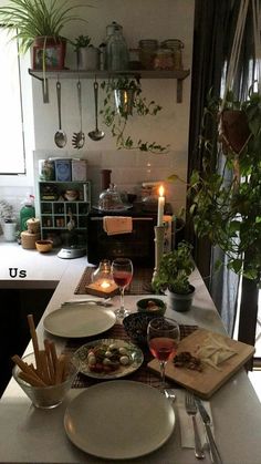 a table with plates, utensils and candles on it