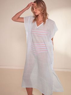 The Nefas Sky Collection features airy gauze fabric in a delicate pale blue color. Perfect for creating a soft and feminine beach look when worn over with colorful swimwear. This classic caftan features a plunge neckline, short cap sleeves, hand-twisted fringe hem making it the perfect beach cover-up. Hand-woven in Ethiopia, this silhouette is made of soft hand-spun cotton for a light and comfortable feel. GIVING BACK | 5% of all purchases will be donated to the lemlem Foundation. Breezy V-neck Beach Dress For Daywear, White V-neck Kaftan For Spring, Beachy White V-neck Cover-up, Short Sleeve Beachwear Cover-up For Daywear, White V-neck Cover-up For Loungewear, White V-neck Loungewear Cover-up, White V-neck Breezy Cover-up, V-neck Cover-up For Beach Season Loungewear, V-neck Beach Season Loungewear Cover-up