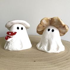 two ceramic mushrooms sitting on top of a wooden table