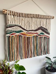 the wall hanging is made from yarn and wood