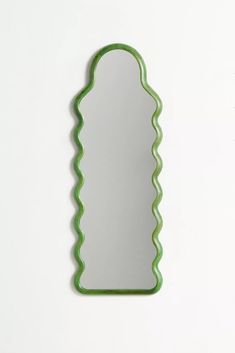 a mirror that is on the wall with a green frame and wavy edges, in front of a white background