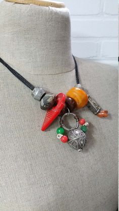 "Lovely Moroccan Berber silver hair ring, silver fibula cap & coral and a resin amber bead on black leather necklace no 3. Easy to wear necklace with a lovely old silver Berber hair ring with little beads, resin amber bead, ceramic bead, old silver fibula cap with coral and a red glass pendant. This is number 3 of 7 necklaces, they are all different so check the pictures what necklace you like best! They make a wonderful gift. All pendants are strung on a black multi strand leather necklace. Black Leather Necklace, Wear Necklaces, Carnelian Beads, Hair Rings, Amber Beads, Summer Necklace, Heishi Beads, Number 3, Silver Pendants