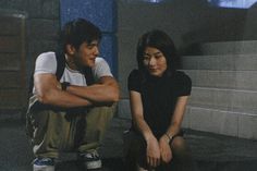 two people sitting on the ground with their arms crossed