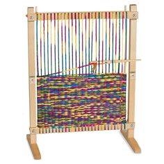 a wooden weaving machine with multicolored yarn on the front and back sides, in an upright position