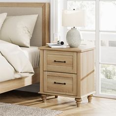 a bedroom scene with focus on the bed and bedside table, which has two drawers