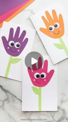 three handprinted cards with flowers on them, one has eyes and the other has hands