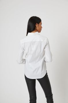 The Icon Shirt runs a bit tailored at the waist, chest and back. For a contemporary fit, order true size. For a blousier fit, size up. Our perfect fit cotton stretch button down. The Shirt reimagined for the perfect fit – powered by No Gape® button technology. Bye bye blouse gape, Hello The Shirt. Patented and designed by Rochelle Behrens to eliminate blouse gape. 75% Cotton, 20% Nylon, 5% Spandex Made in Portugal Powered by No Gape® button technology P - TS1000 - Essentials Solids P - TS1000 - Fitted Business Casual Tops With Shirttail Hem, Fitted Tops With Shirttail Hem For Workwear, Fitted Shirttail Hem Top For Office, Modern Fitted Blouse With Spread Collar, Fitted Formal Tops With Shirttail Hem, Fitted Blouse With Shirttail Hem For Business Casual, Fitted Shirt With Shirttail Hem For Formal Occasions, Fitted Shirttail Hem Blouse For Office, Fitted Blouse With Shirttail Hem For Office