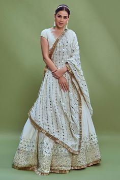 Ivory chanderi lehenga with mirror embroidery on the border and fringe detail at the hem. Comes with blouse and dupatta.
Component: 3
Pattern: Embroidery
Type Of Work: Mirror, Thread and Beads
Neckline: V neck
Sleeve Type: Cap
Fabric: Blouse: Satin Glace, Lehenga: Heavy Chanderi and Dupatta: Linen
Color: White
Other Details: 
Blouse with scalloped border and bead drops
Dupatta with mirror embroidery and fringe border
Tie up at the back
Occasion: Bride - Aza Fashions Lehenga Heavy, Chanderi Lehenga, Abhinav Mishra, Blouse Satin, Lehenga Pattern, Embroidery Mirror, Mirror Embroidery, Scalloped Border, White Mirror