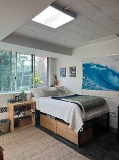 a bed room with a neatly made bed next to a window and a painting on the wall