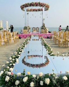 an outdoor wedding ceremony setup with flowers and greenery on the table, along with chairs