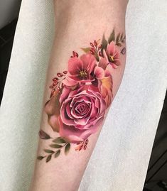 a woman's leg with a rose tattoo on it