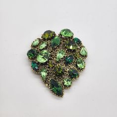 WEISS GREEN Rhinestone Brooch Signed Uranium Stones Vintage  This is a beautiful signed Weiss olive and lime green rhinestones brooch.  It would look great on denim shirt, jacket, scarf, etc.  Or add it to your vintage jewelry collection or uranium/vaseline glass collection. It's very pretty!  Please see all pictures. Green Costume Jewelry Brooches For Gift, Green Costume Jewelry Brooches For Gifting, Vintage Green Brooch For Party, Vintage Green Rhinestone Brooches, Green Vintage Rhinestone Brooches, Vintage Green Rhinestone Brooch, Green Jeweled Brooch For Gift, Green Jeweled Brooches As Gift, Green Jeweled Brooch Gift