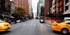 two taxi cabs driving down a city street