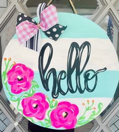 a hand painted sign that says hello with pink flowers and polka dots on the front