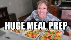 a woman sitting at a table with two trays of food in front of her