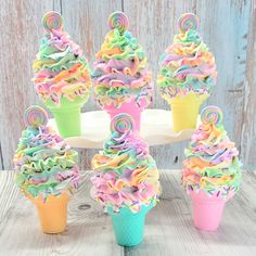 cupcakes decorated with rainbow icing and sprinkles on a cake stand