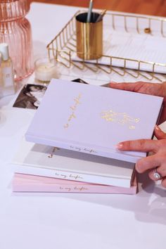 a person holding a book on top of a table