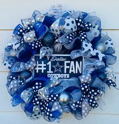 a blue and white wreath with polka dots, silver balls and bows on it that says 1 fan