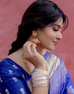 a woman in a blue sari with gold jewelry