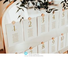 the table numbers are arranged in gold and white, with greenery on each side