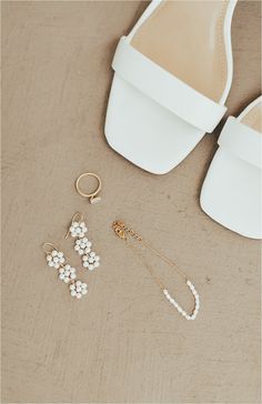 two pairs of white shoes, one with pearls and the other with gold - plated earrings