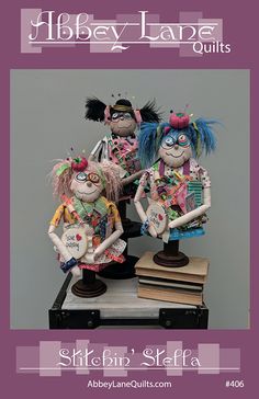 three dolls are sitting on top of a table with books in front of them and the words, hibby - lampe quilts