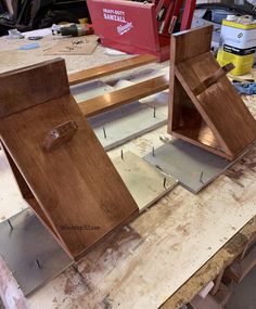 two pieces of wood sitting on top of a wooden workbench with tools in the background