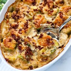 a white casserole dish filled with brussel sprouts and bacon