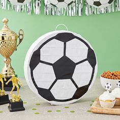 a table topped with trophies and soccer balls