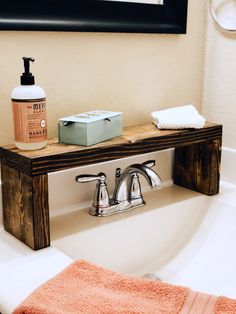 a bathroom sink with soap, hand sanitizer and towel on the shelf next to it